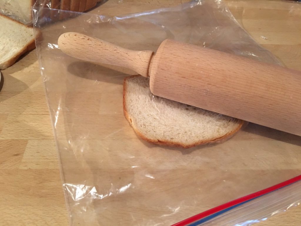 Das Brot mit dem Nudeholz platt rollen